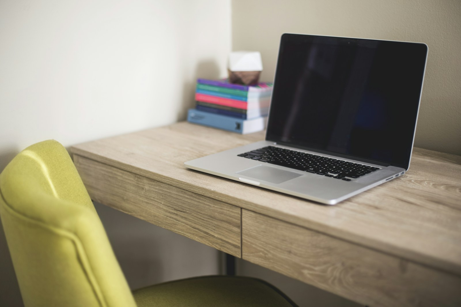 An empty office chair beside a desk with a laptop—ready for a call or message.